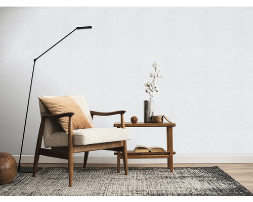 Woonkamer met fauteuil, vloerlamp, vloerkleed en bijzettafel