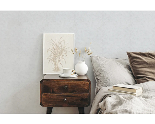 Slaapkamer met houten nachtkastje, kopje, vaas en ingelijste foto