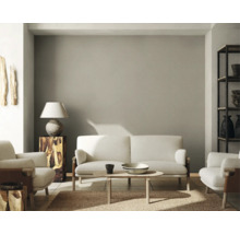 Woonkamer met bank, fauteuils, tafel, lamp en plank.