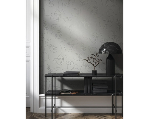 Behang met vrouwengezichten in interieur met console en decoratie.