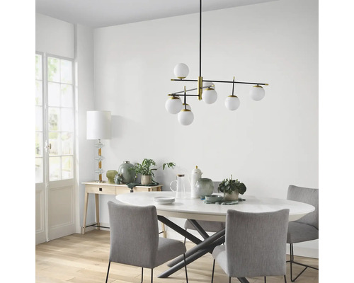 Eettafelscène met een moderne hanglamp met meerdere glazen bollen.