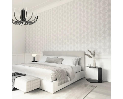 Slaapkamer met tweepersoonsbed, nachtkastje en behang met motief