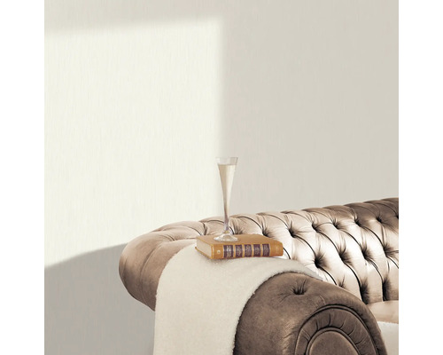 Close-up van een gestructureerd behang in een interieur met een bank, boek en glas