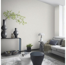 Woonkamer met gestructureerd behang, bank en decoratieve elementen voor een stijlvol interieur