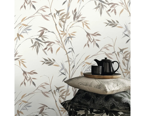 Decoratieve scène met bamboepatroon behang, kussens en theeservies.