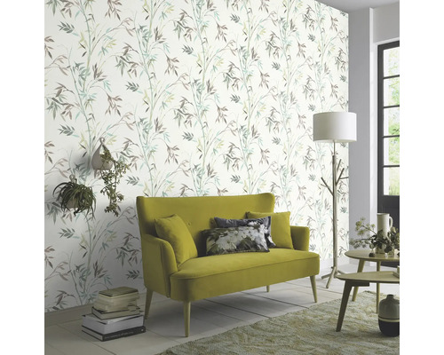 Woonkamer met patroonbehang, bank en decoraties voor een lichte sfeer.