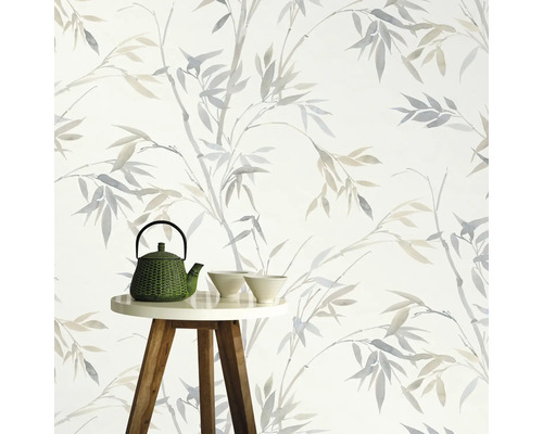 Decoratief behang met bamboepatroon op de achtergrond, theepot en kommen op een kleine tafel