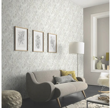 Woonkamer met bloemenbehang, bank en decoraties voor een lichte en vriendelijke sfeer.