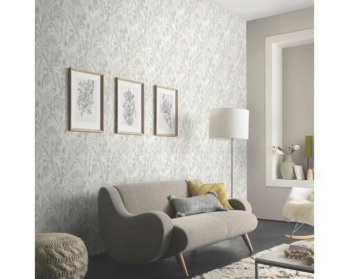 Woonkamer met bloemenbehang, bank en decoraties voor een lichte en vriendelijke sfeer.