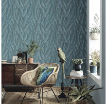 Woonkamer met patroonbehang, rotan stoel en decoratie