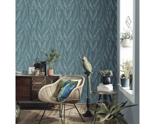 Woonkamer met patroonbehang, rotan stoel en decoratie