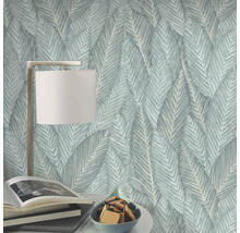 Decoratief behang met bladerpatroon, tafellamp, boeken en schaal met koekjes