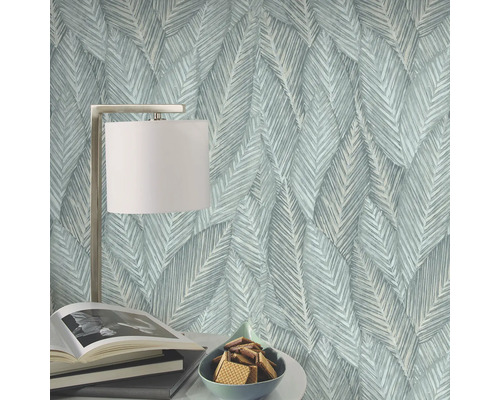 Decoratief behang met bladerpatroon, tafellamp, boeken en schaal met koekjes