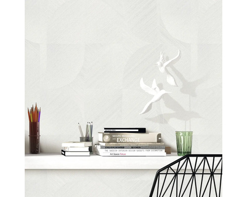 Decoratieve wanddecoratie met boeken en vogelbeeldjes op een bureau