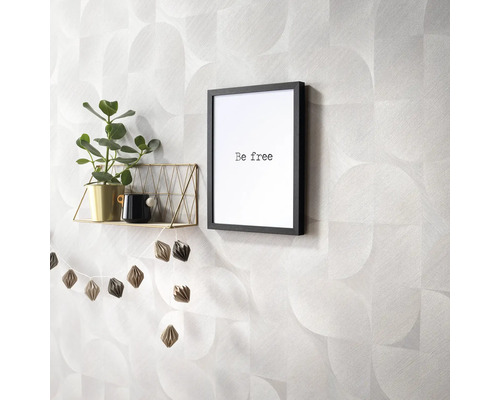 Decoratieve wanddecoratie met geometrisch behangpatroon, plank, kamerplant en ingelijste belettering