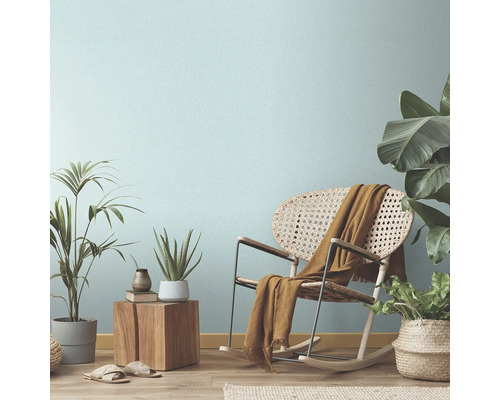 Woonkamerscène met schommelstoel, planten en decoratieve elementen voor een gezellige sfeer.