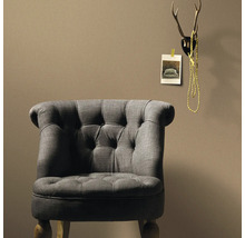 Grijze fauteuil met knoopdetails voor een wand
