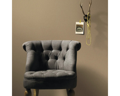 Grijze fauteuil met knoopdetails voor een wand