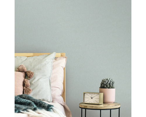 Slaapkamer met bed, nachtkastje, klok, vetplant en textielbehang