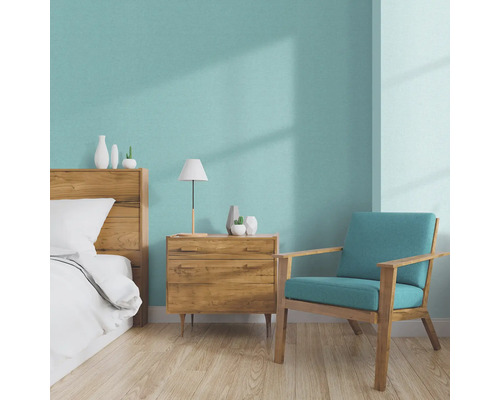 Lichte slaapkamer met houten bed, nachtkastje, lamp en fauteuil