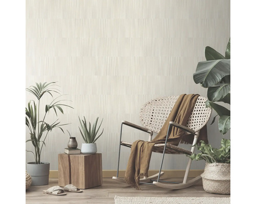 Lichte woonkamer met behang met patroon, schommelstoel en kamerplanten voor een uitnodigende sfeer.