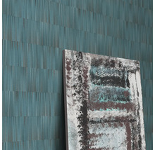Detailopname van een muur met een abstract behang en een abstract schilderij.