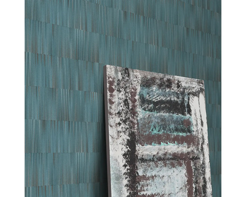 Detailopname van een muur met een abstract behang en een abstract schilderij.