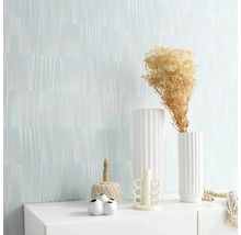 Woonkamer met een wand met motief en decoraties op een witte kast