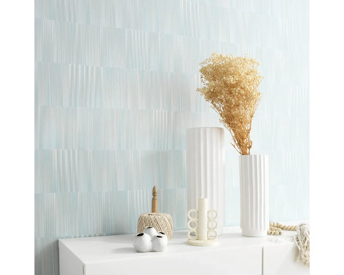 Woonkamer met een wand met motief en decoraties op een witte kast