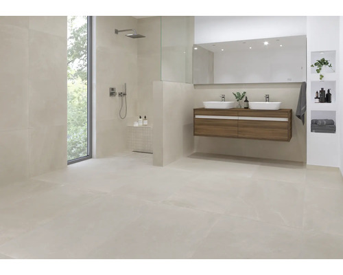 Lichte badkamer met douche, wastafel en grootformaat tegels.