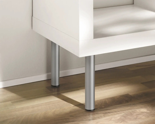 Detailopname van een wit meubelstuk met zilverkleurige poten op een houten vloer