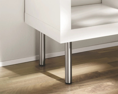 Detail van een meubelstuk met metalen poten op een houten vloer.