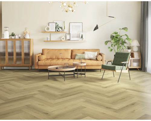 Woonkamer met visgraatparket, bank en decoraties voor een gezellige sfeer.