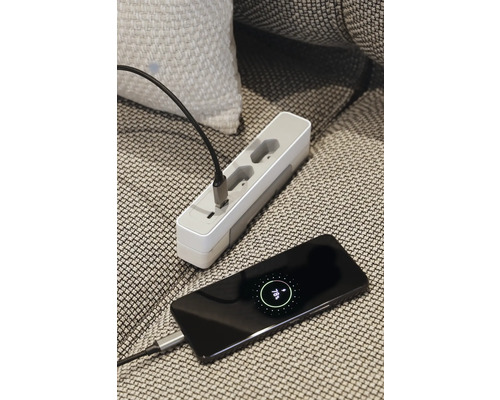 Meervoudig stopcontact en een smartphone worden met een laadkabel verbonden.