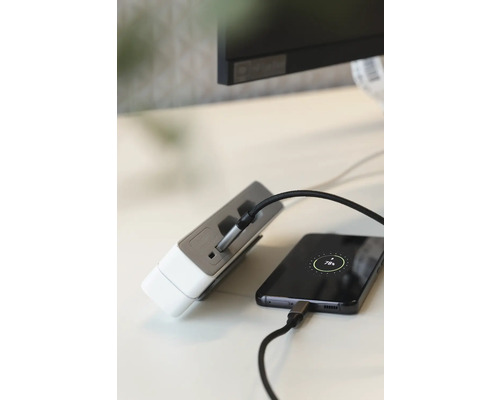 Meervoudige stekkerdoos met USB-aansluitingen laadt een mobiele telefoon op