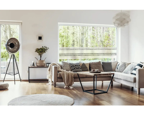 Woonkamer met bank, salontafel, vloerlamp en decoratieve kussens