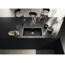 Spoelbak in een modern kookeiland met kraan, servies en decoratie