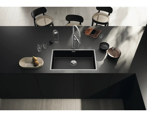 Spoelbak in een modern kookeiland met kraan, servies en decoratie