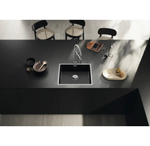 Spoelbak met kraan op een aanrecht met vaatwerk en decoratie