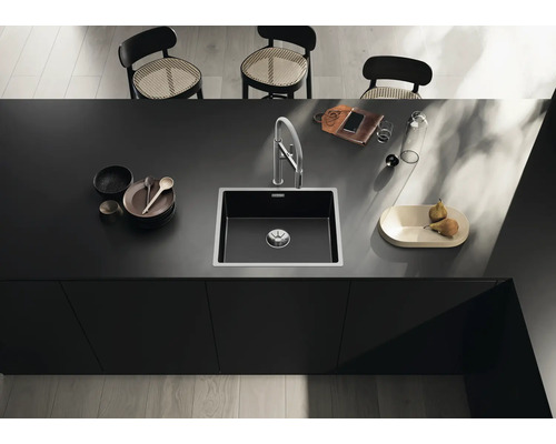 Spoelbak met kraan op een aanrecht met vaatwerk en decoratie