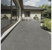 Terras met grijze tegels en zithoek in de tuin