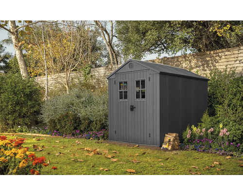 Tuinhuisje in de tuin met stapel hout