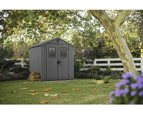 Tuin met gereedschapsschuur, houten hek en boom