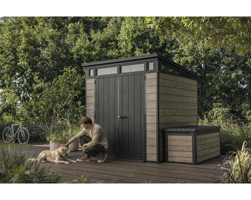 Tuinscene met tuinhuis en opbergbox, man aait hond