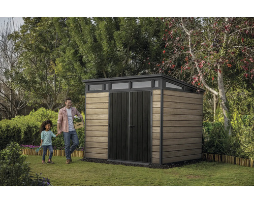 Tuinscène met tuinhuis, man en kind op gazon.