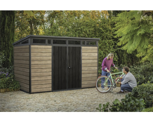 Tuinkast met lessenaarsdak, houten wand en een paar mensen met een fiets in de tuin