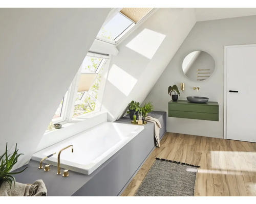 Badkamer met dakramen, bad, wastafel en spiegel in een lichte ruimte