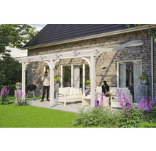Terras met houten pergola en zitgroep op een bestrate ondergrond naast een huis.