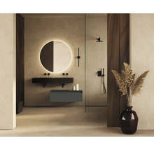 Badkamer met ronde spiegelverlichting, wastafel, douchearmatuur en decoratie