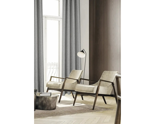 Woonkamer met fauteuils, staande lamp en gordijnen